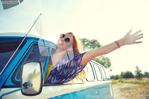 Image of smiling young hippie woman driving minivan car