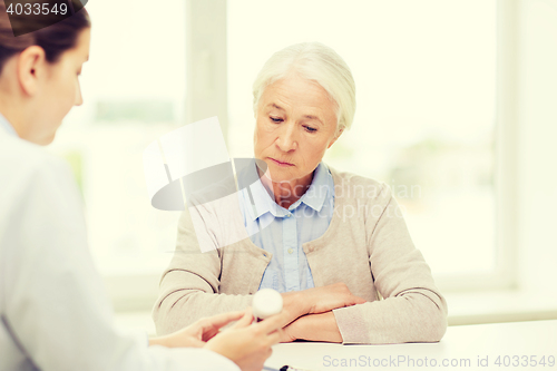 Image of doctor with medicine and senior woman at hospital