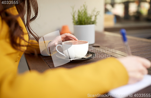 Image of close up of woman drinking cocoa at cafe