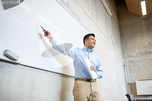 Image of teacher pointing marker to white board at lecture