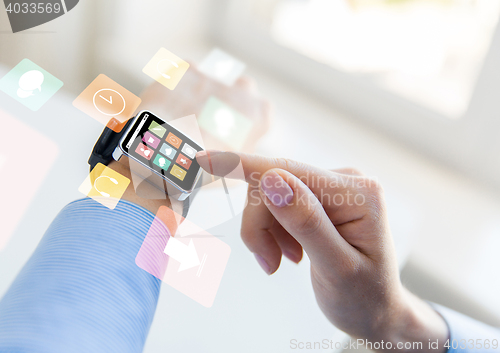 Image of close up of hands setting smart watch with icons