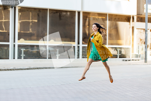 Image of happy young woman or teenage girl on city street
