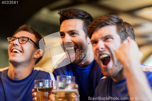 Image of football fans or friends with beer at sport bar