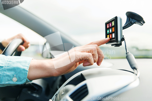 Image of close up of man with icons on gadget driving car