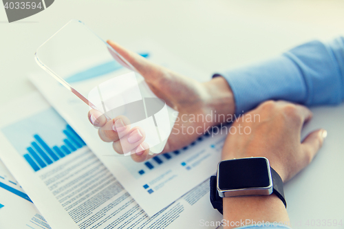 Image of close up of hands with smart phone and watch