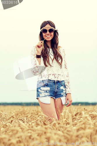 Image of smiling young hippie woman on cereal field