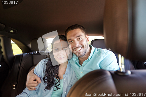 Image of happy man and woman hugging in car