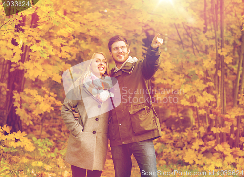 Image of smiling couple hugging in autumn park