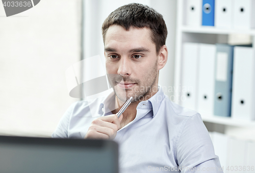 Image of young businessman with laptop computer at office