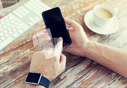 Image of close up of hands with smart phone and watch