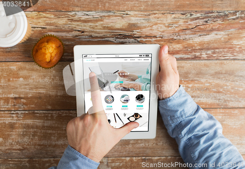 Image of close up of hands with online shop on tablet pc