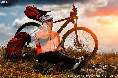 Image of Sportive Man Stops Cycling and Has a Rest on Valley