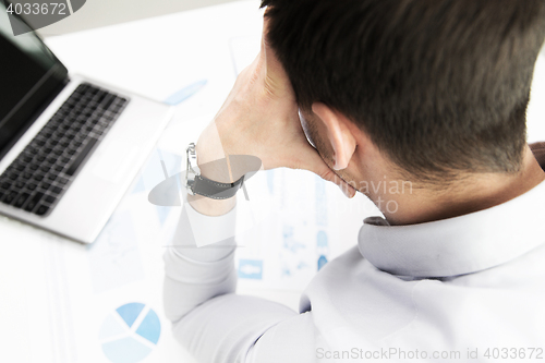 Image of close up of businessman with laptop and papers