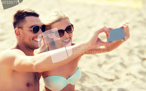 Image of happy couple in swimwear walking on summer beach