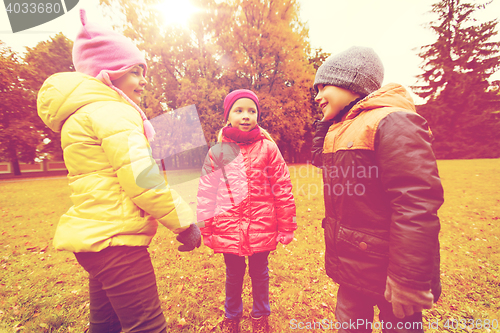 Image of group of happy children talking in autumn park