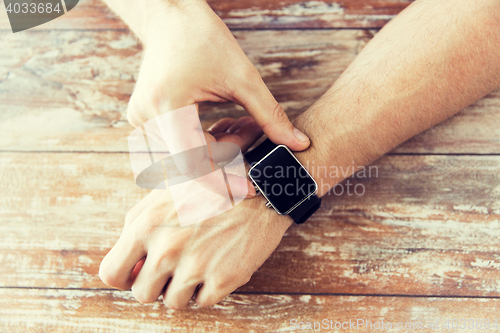 Image of close up of male hands setting smart watch