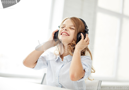 Image of smiling little girl with headphones at home