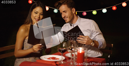 Image of Loving young couple choosing food off a menu