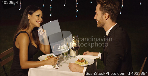 Image of Couple eats spaghetti at fancy outdoor restaurant