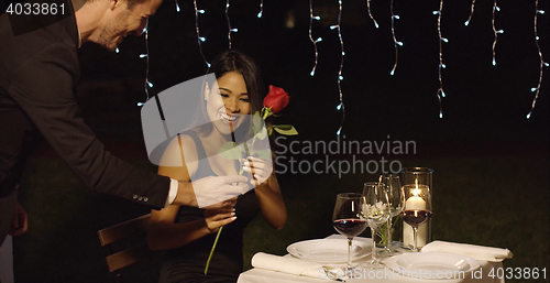 Image of Romantic man surprising his date with a rose