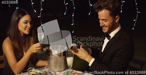 Image of Man fills his glass with champagne to toast