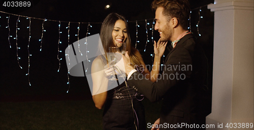 Image of Handsome couple flirts with champagne in hand