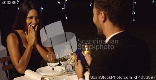 Image of Young woman overcome when presented with a gift