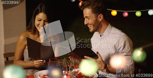 Image of Young couple laughing as they go through the menu