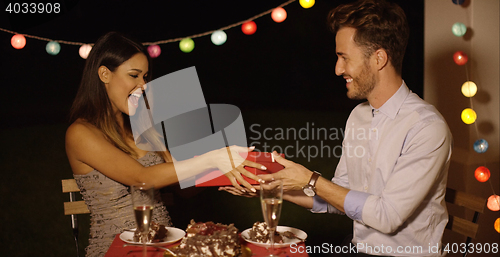 Image of Happy young woman receiving a Valentines gift