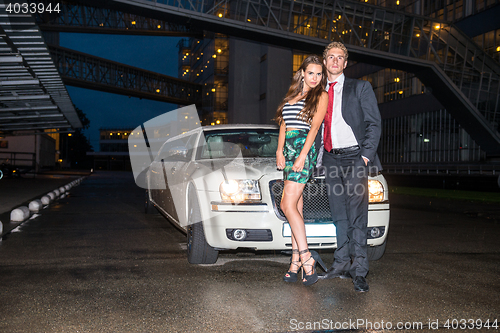 Image of Full length portrait of elegant young couple standing in front o