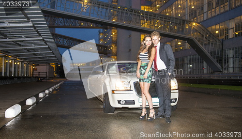 Image of Cute couple in front of a limousine