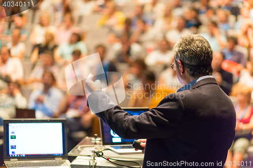 Image of Public speaker giving talk at Business Event.