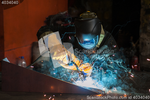 Image of worker welding metal