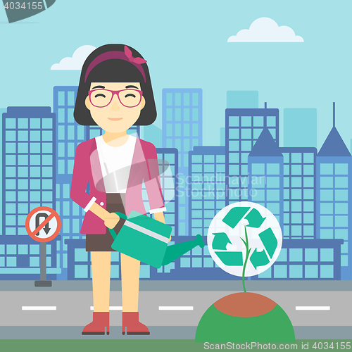 Image of Woman watering tree with recycle sign.