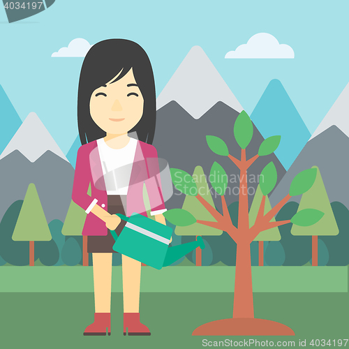 Image of Woman watering tree with light bulbs.