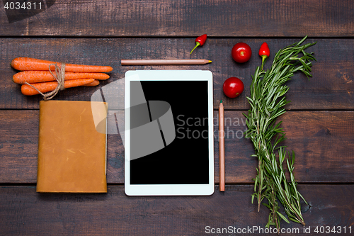 Image of The tablet, notebook, fresh bitter and sweet pepper on wooden table background