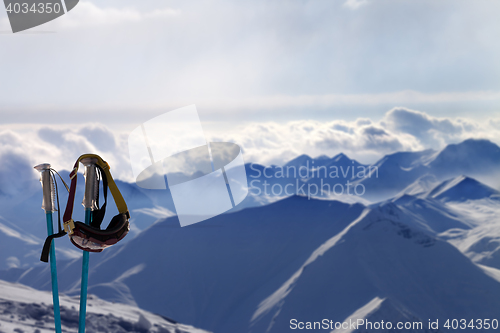 Image of Ski mask on ski poles in evening sunlight mountains