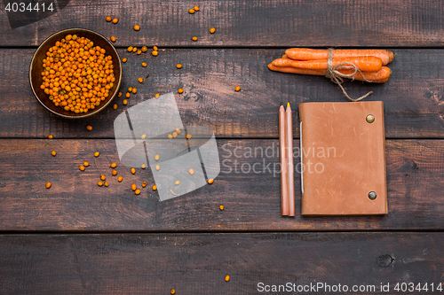 Image of Office desk table with notebooks, fresh buckthorn berries on wooden table