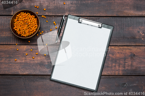 Image of Office desk table with notebooks, fresh buckthorn berries on wooden table