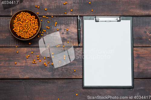 Image of Office desk table with notebooks, fresh buckthorn berries on wooden table