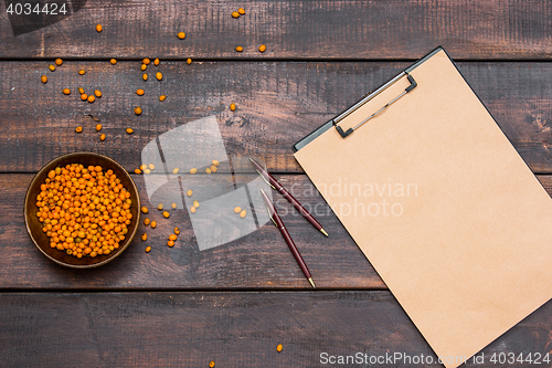 Image of Office desk table with notebook, fresh buckthorn berries on wooden table