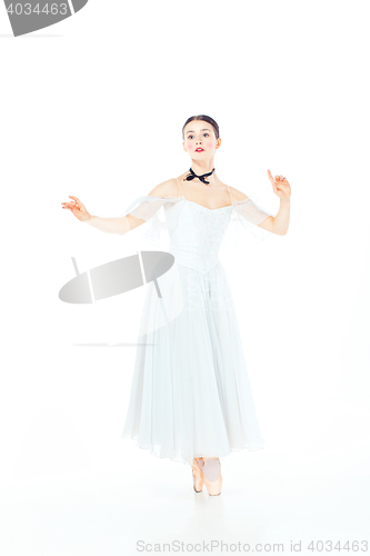 Image of Ballerina in white dress posing on pointe shoes, studio background.