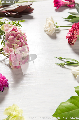 Image of The flowers on white wooden background