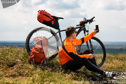 Image of Sportive Man Stops Cycling and Has a Rest on Valley