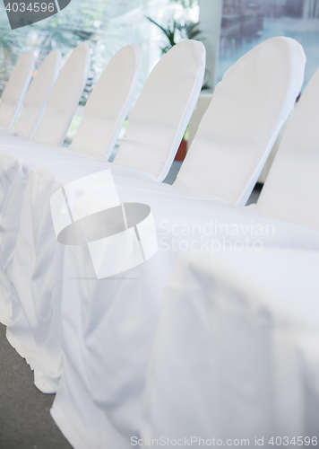 Image of chairs with white fabric cover for celebrations