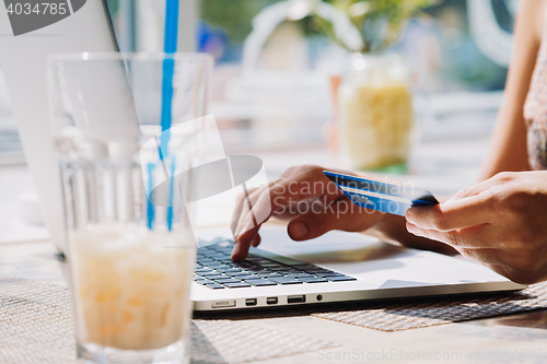 Image of woman using laptop with credit card in hand