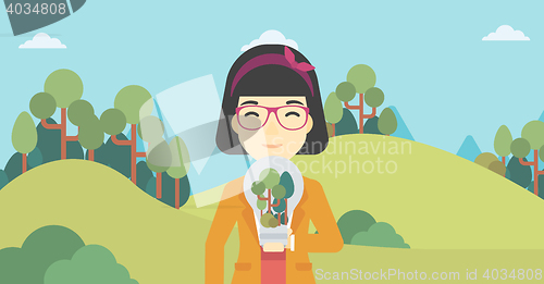 Image of Woman with lightbulb and trees inside.