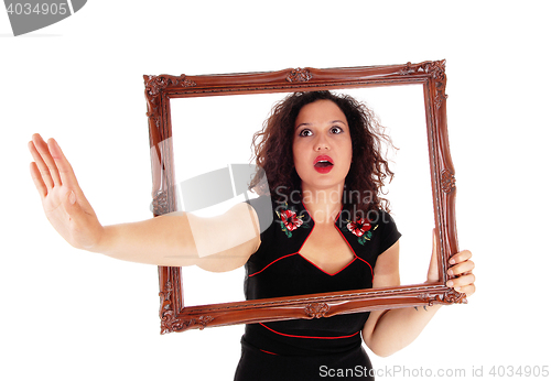 Image of Woman looking trough picture frame.