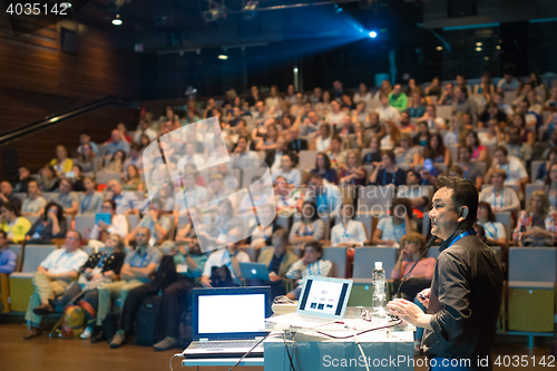 Image of Public speaker giving talk at Business Event.