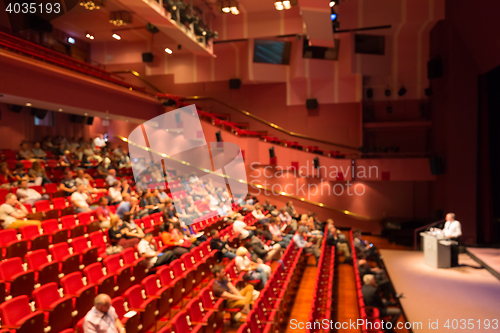 Image of Business speaker giving a talk in conference hall.